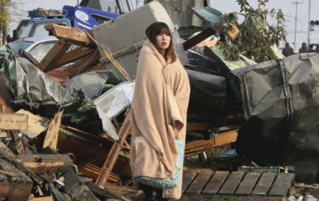 Một phụ nữ thất thần nhìn cảnh đổ nát ở Ishinomaki, quận Miyagi. Ảnh: AP