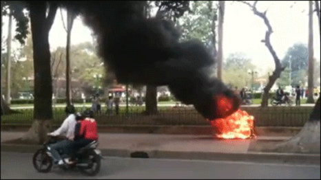 Đốt xe máy trước cửa đại sứ quán TQ để phản đối (ảnh lấy từ video clip)