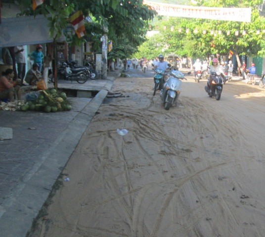 Đất cát tràn xuống lòng đường gây khó khăn cho người đi xe máy