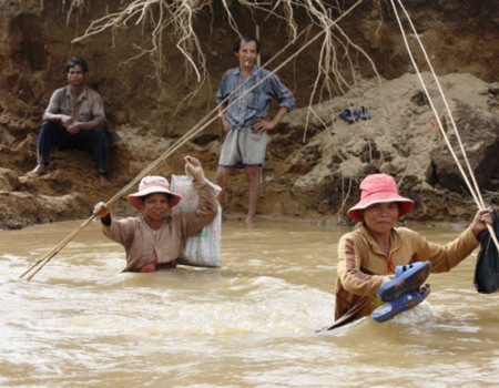 Phụ nữ phải vượt suối vì đường giao thông không thể đi.