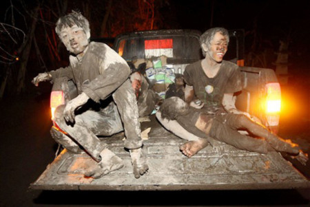 Người dân sơ tán bằng xe tải với cơ thể bị phủ đầy tro bụi từ núi lửa Merapi