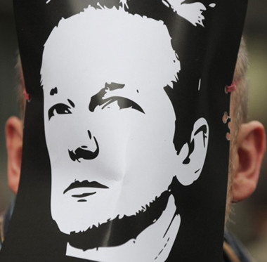 Một người biểu tình mang chân dung của Assange bên ngoài toàn án Westminster City, Anh hôm 7/12. Ảnh: AFP