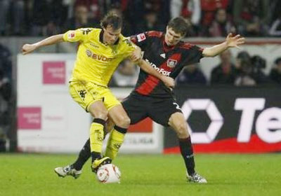 Grosskreutz (áo vàng) tranh bóng với một cầu thủ Leverkusen.