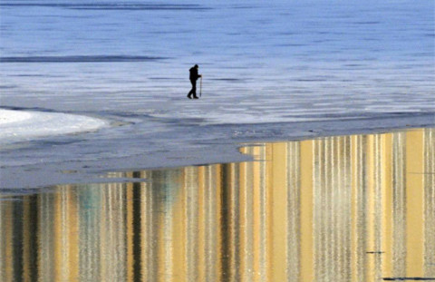 Người đàn ông Ukraina đi bộ trên dòng sông Dnieper đóng băng ở Kiev. Ảnh: AP.