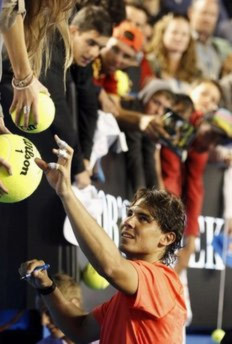 Nadal ký tặng người hâm mộ sau trận đánh tối qua.