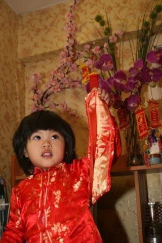 Cháu Phạm Kim Oanh, 3 tuổi, đang sinh sống cùng bố mẹ tại Moscow và chụp ảnh bên cạnh những cành đào, cành hoa lan giả.