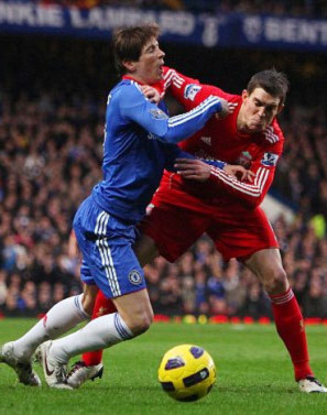 Torres (xanh) tranh chấp bóng với Agger ở trận đấu gần đây.