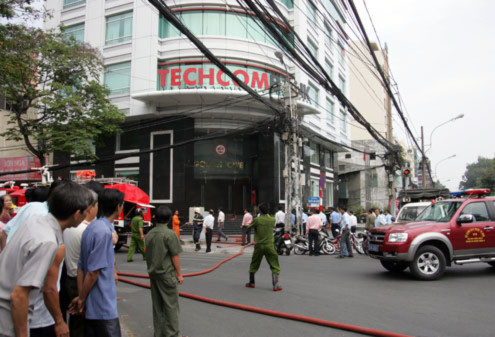 Lực lượng cứu hỏa triển khai dập tắt lửa trong tòa nhà ngân hàng. Ảnh: An Nhơn.