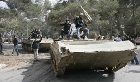 Người biểu tình nhảy múa trên một chiếc xe tăng ở thành phố miền đông Albayda. Ảnh: AP/CNS