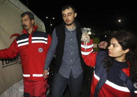 Hai nhân viên thuộc Tổ chức Chữ thập đỏ đưa một công nhân Thổ Nhĩ Kỳ