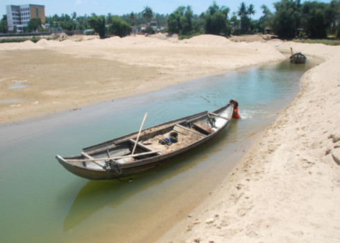 Nước sông Trà mỗi năm một xuống thấp, trơ đáy, những người khai thác cát sạn phải đào một mương nhỏ sâu 4 m để đưa ghe chở hàng vào bờ. Ảnh: Trí Tín