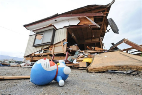Chú Doraemon đồ chơi nằm bên ngoài một căn nhà bị tàn phá bởi động đất ở thành phố Ofunato. Ảnh: AFP.