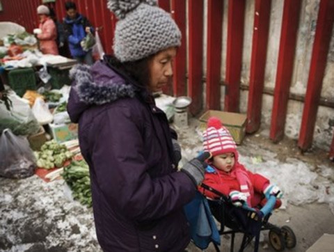 Một phụ nữ tần ngần khi đi chợ mua rau ở Bắc Kinh, Trung Quốc. Ảnh: AP