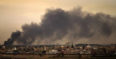 Khói đen kịt bốc lên trên bầu trời ngoại ô Benghazi ngày 19/3/2011. Quân nổi dậy cáo buộc các lực lượng chính phủ sáng qua vẫn tiếp tục tiến hành các cuộc tấn công vào Benghazi bất chấp tuyên bố ngừng bắn trước đó