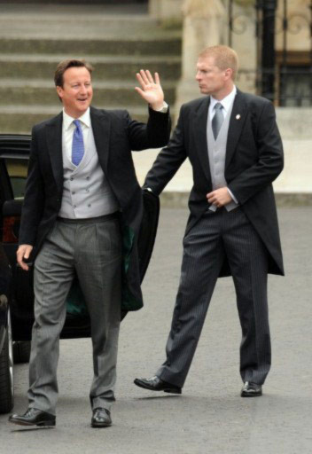 Thủ tướng James Cameron giơ tay vẫy chào đám đông khi vừa đến Tu viện Westminster.