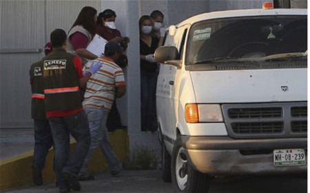 Vận chuyển thi thể các nạn nhân trong hố chôn tập thể ở Mexico. Ảnh: AP