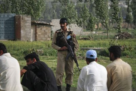 Một binh sĩ Pakistan nhìn về phía những người dân tụ tập bên ngoài dinh thự mà bin Laden ẩn náu tại thị trấn Abbottabad vào ngày