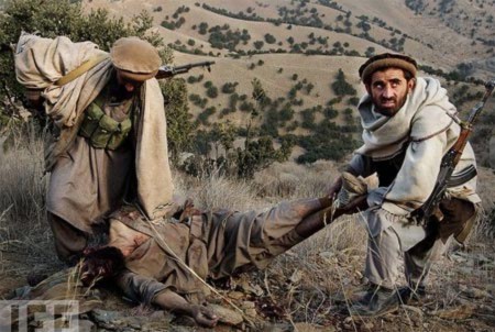 Binh sĩ Afghanistan hỗ trợ Mỹ trong chiến dịch Tora Bora khiêng thi thể một chiến binh Al-Qaeda. Ảnh: Life.
