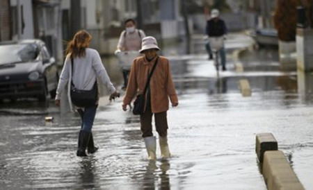 Người dân đi trên một đường phố ngập nước biển tại thành phố Ishinomaki vào ngày 3/5. Ảnh: AP.