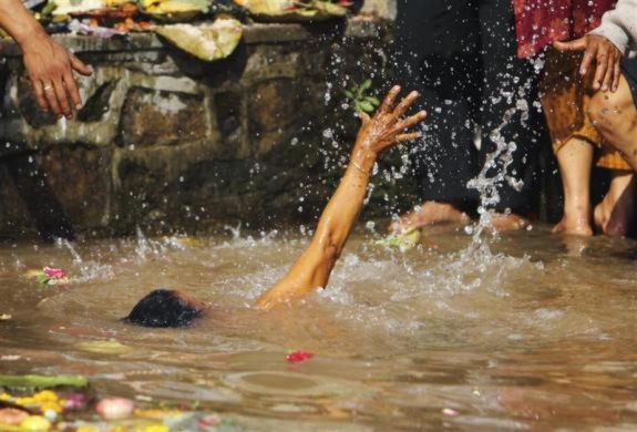 Một phụ nữ đang dơ tay gọi người cứu sau khi bị trượt chân ngã xuống trước trong khi đang tắm nước thánh ở Matathirtha, Nepal. Nhưng người phụ nữ này đã không may mắn bị tử nạn sau đó.