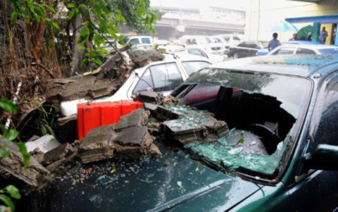 Những chiếc xe hơi bị hư hỏng do tường đổ đè vào, ở Manila.