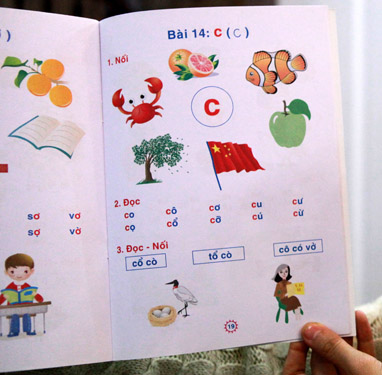 Trang sách dạy các em học chữ C (trong cuốn Bé làm quen với chữ cái) có in lá cờ của Trung Quốc - Ảnh: Tuấn Phùng