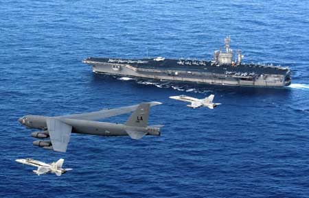 Một máy bay ném bom B-52 cùng 2 chiến đấu cơ F/A-18 Hornets bay gần tàu sân bay Mỹ USS Nimitz.