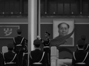 Một sĩ quan cảnh sát bán quân sự nhặt lá cờ Trung Quốc ở phía trước của bức chân dung của Mao Trạch Đông tại Quảng trường Thiên An Môn ở Bắc Kinh vào ngày 02 tháng Ba. Đài truyền hình Trung ương Trung Quốc mới đây trích dẫn lời Mao nói rằng ông sẵn sàng nghe tin hàng trăm triệu người Trung Hoa bị giết. (Feng Li / Getty Images)