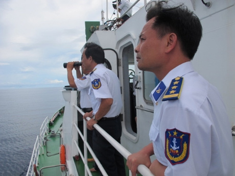 Các chiến sĩ cảnh sát biển sử dụng ống nhòm quan sát những chiếc tàu cá lạ từ xa.