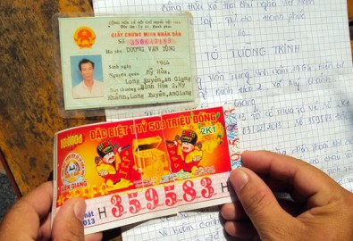 Tờ vé số trúng thưởng của ông Tùng bị rách làm đôi nhưng khi ghép lại vẫn còn đầy đủ hình dạng - Ảnh: Đức Vịnh
