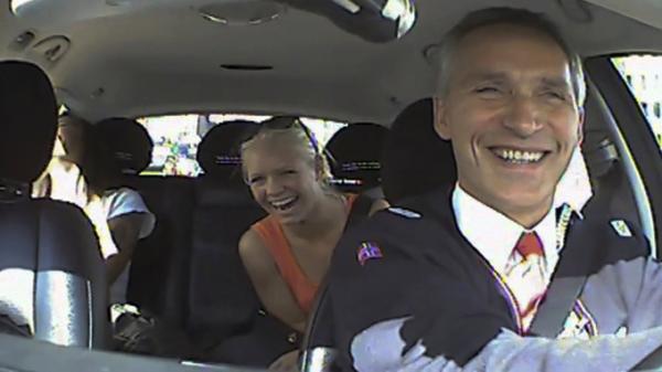 Thủ tướng Jens Stoltenberg tươi cười khi nói chuyện với các hành khách trong taxi do mình lái - Ảnh: Reuters