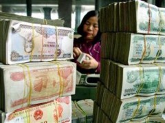 Đếm tiền tại một ngân hàng ở Hà Nội.
Reuters