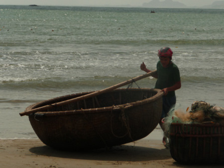 Ngư dân trẻ một mình gắng sức đưa thuyền lên bờ tránh bão. Ngư dân trẻ một mình gắng sức đưa thuyền lên bờ tránh bão.