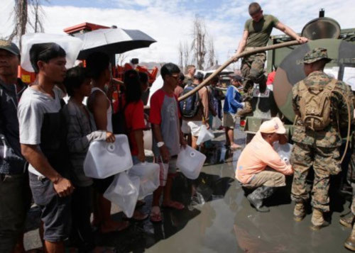 Quân đội Mỹ cung cấp nước uống cho nạn nhân siêu bão ở thành phố Tacloban. Ảnh: AP