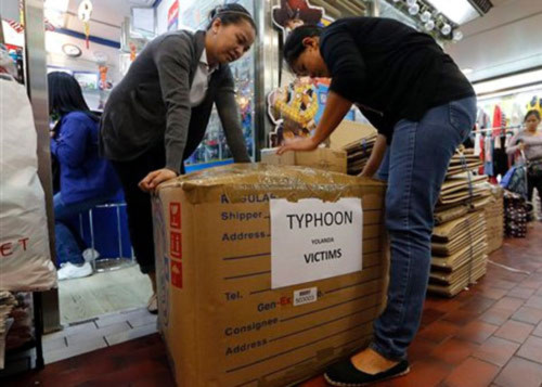 Công nhân Philippines ở Hồng Kông quyên tiền gửi về quê nhà. Ảnh: AP