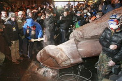 Đám đông quá khích dùng rìu đập phá tượng Lenin sau khi đã giật ngã bức tượng cao hơn 3 m này bằng dây thừng - Ảnh: Reuters