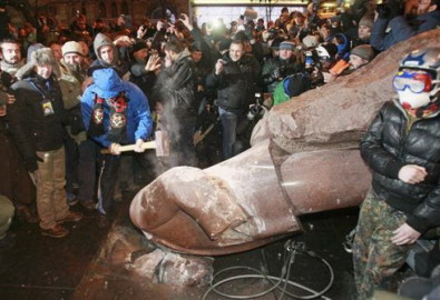 Đám đông quá khích dùng rìu đập phá tượng Lenin sau khi đã giật ngã bức tượng cao hơn 3 m này bằng dây thừng - Ảnh: Reuters