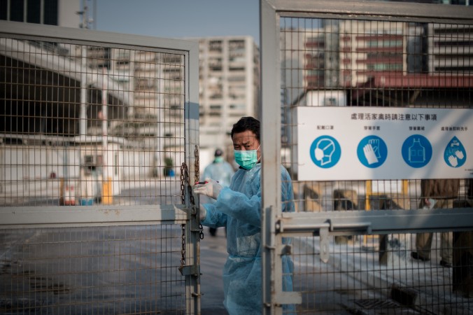 Một nhân viên bảo vệ đóng cửa chợ gia cầm tại Hồng Kông hôm 28 tháng Một. Một sự bùng nổ số người nhiễm cúm gia cầm tại Trung Quốc, với một chủng virus mới đã tái xuất hiện (PHILIPPE LOPEZ/AFP/Getty Images)
