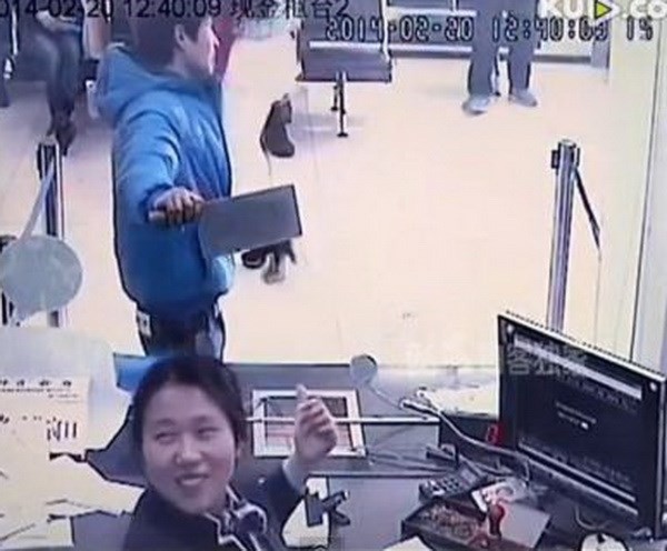 Hành động khác người của cả cô nhân viên lẫn tên cướp. (Nguồn: You Tube) Hành động khác người của cả cô nhân viên lẫn tên cướp. (Nguồn: You Tube)