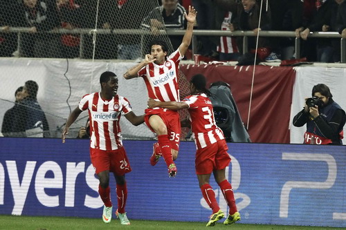 Olympiakos' midfielder Dominguez celebrates with teammates after scoring against Manchester United during their Champions League match in Piraeus