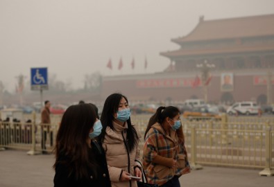 Người dân đi bộ trên Quảng trường Thiên An Môn phải đeo khẩu trang trong suốt đợt ô nhiễm – ảnh chụp vào ngày 25 tháng Hai 2014 tại Bắc Kinh. Phòng cấp cứu tiêm truyền và hồi sức tại các bệnh viện đã quá tải với số lượng bệnh nhân nhập viện (Lintao Zhang/Getty Images)