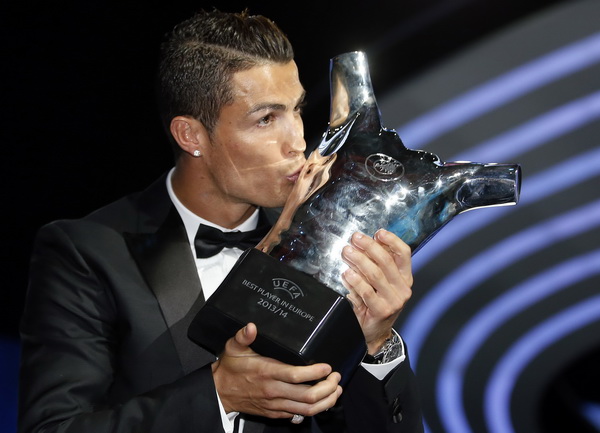 Real Madrid's Cristiano Ronaldo kisses his Best Player UEFA 2014 Award during the draw ceremony for the 2014/2015 Champions League Cup soccer competition in Monaco