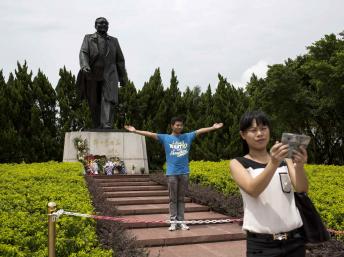 Khách du lịch chụp hình kỷ niệm trước tượng Đặng Tiểu Bình tại Thâm Quyến, Quảng Đông. Ảnh chụp ngày 19/08/2014. REUTERS/Tyrone Siu