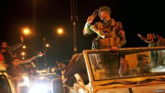Người dân ở Dohuk, Thổ Nhĩ Kỳ vẫy chào các chiến binh Peshmerga của người Kurd trên đường đến thị trấn Kobani ở Syria, ngày 28/10/2014.