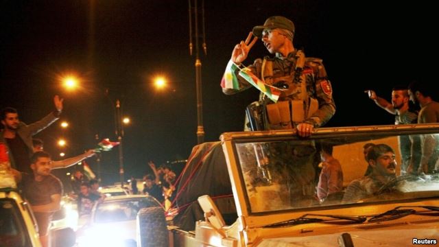 Người dân ở Dohuk, Thổ Nhĩ Kỳ vẫy chào các chiến binh Peshmerga của người Kurd trên đường đến thị trấn Kobani ở Syria, ngày 28/10/2014.