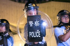 Cuộc đụng độ giữa cảnh sát và những người biểu tình sau khi người biểu tình chặn đường Lung Wo – một trong những tuyến đường chính ở Hồng Kông – vào ngày 15/10/2014. Đêm 15/10, cảnh sát trả đũa bằng việc đánh đập người biểu tình bằng nắm đấm, dùi cui, và hơi cay (Benjamin Chasteen/Epoch Times)