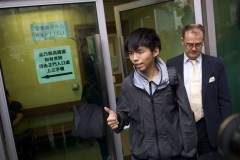 Thủ lĩnh phong trào biểu tình sinh viên ở Hồng Kông, Joshua Wong (Hoàng Chi Phong), đứng giữa, cùng luật sư bước ra khỏi tòa án ở Hồng Kông, ngày 27/11/2014. Wong và những người biểu tình dân chủ khác bị bắt giữ trong đợt trấn áp của cảnh sát nhằm dẹp bỏ những chướng ngại vật của người biểu tình tại quận Mong Kok. Wong được tại ngoại và vụ xét xử được hoãn lại đến ngày 14/1. (Ảnh Internet)
