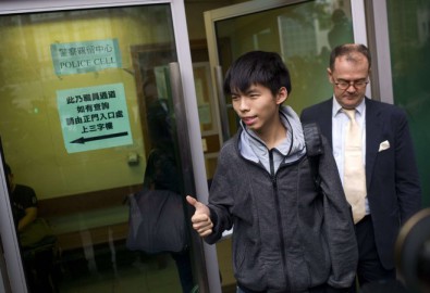 Thủ lĩnh phong trào biểu tình sinh viên ở Hồng Kông, Joshua Wong (Hoàng Chi Phong), đứng giữa, cùng luật sư bước ra khỏi tòa án ở Hồng Kông, ngày 27/11/2014. Wong và những người biểu tình dân chủ khác bị bắt giữ trong đợt trấn áp của cảnh sát nhằm dẹp bỏ những chướng ngại vật của người biểu tình tại quận Mong Kok. Wong được tại ngoại và vụ xét xử được hoãn lại đến ngày 14/1. (Ảnh Internet)