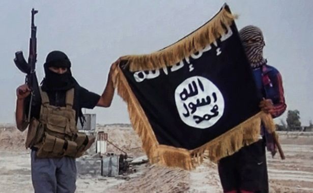 Militanţi ai Statului Islamic pozează alături de steagul grupului jihadist. (Getty Imges)