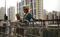 Một công nhân xây dựng Trung Quốc ngáp khi đang quét sơn phía bên ngoài của một khu phức hợp căn hộ mới ngày 29/8/2014 ở Bắc Kinh, Trung Quốc. Việc xây dựng nhanh chóng và đầu tư tràn lan vào bất động sản ở Trung Quốc đã tạo ra một bong bóng, và bong bóng này đang dần dần xì hơi. (Ảnh: Kevin Frayer/Getty Images)